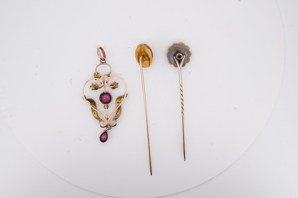 An Edwardian 15ct, diamond and seed pearl cluster set stick pin, 54mm, a similar yellow metal and cabochon garnet set stick pin and an Edwardian 9ct and gem set drop pendant. Condition - poor to fair